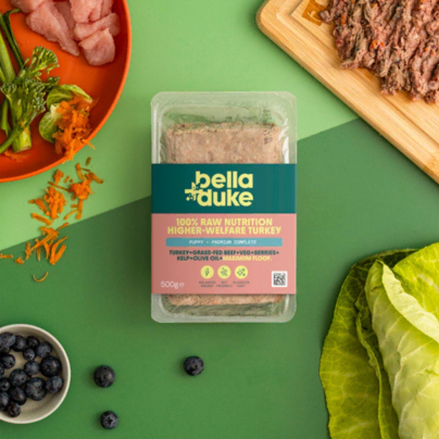 Packaged food product with bella+duke branding on a green background with ingredients around it.
