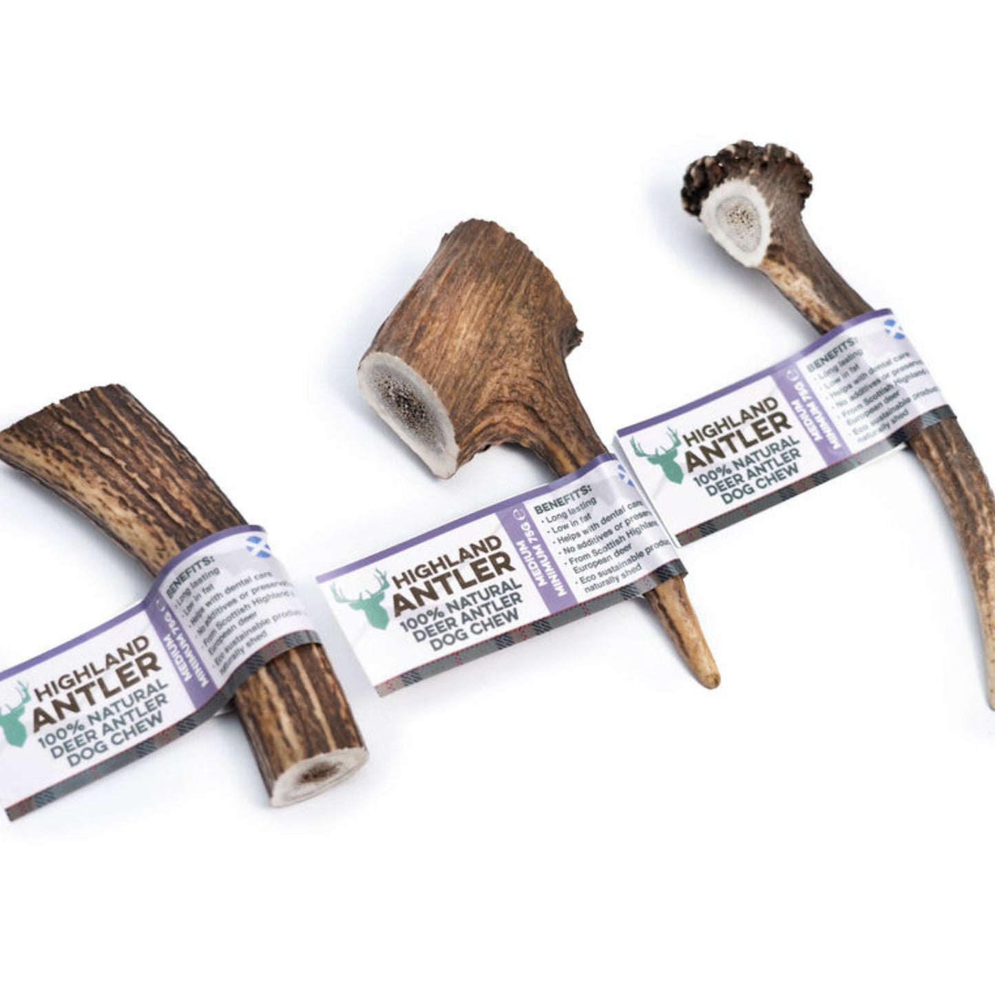 Three Highland Antler 100% natural deer antler dog chews with paper bands, arranged on a plain white background.