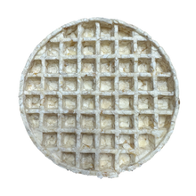 Round waffle-like dessert with a grid pattern on a white background