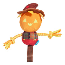 A plush scarecrow dog toy with a round orange face, brown hat, red plaid shirt, and braided yellow and orange rope arms, shown on a plain white background.
