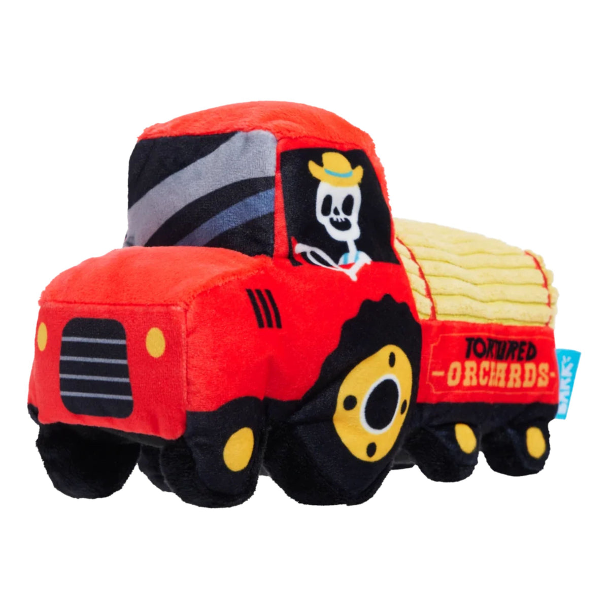 A plush toy shaped like a red tractor carrying a yellow striped load, with black wheels and a skull-and-crossbones driver's license graphic on the window. 