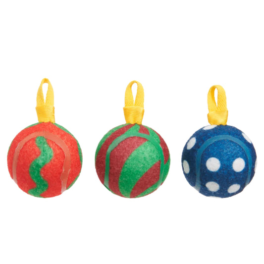 Three textured tennis balls shaped like Christmas ornaments hanging from yellow ribbons. The left ornament is red and green, the middle is green and red, and the right is blue with white polka dots.
