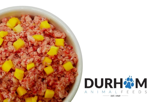 Dog food with mango chunks in a bowl, branded with Durham Animal Feeds.