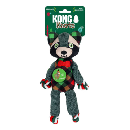 Kong Raccoon Squeaks plush dog toy in retail packaging, featuring a raccoon dressed in a red, green, and black plaid outfit with a red bow tie