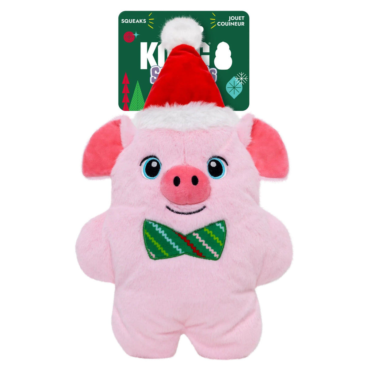 A pink plush pig dog toy with a red Santa hat and green bow tie, shown with its green retail tag behind it on a white background.