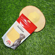 Pawmesan dog treat packaging with the top open on a wooden block on grass.