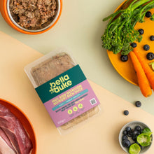 Packaged food with bella+duke branding on a table with vegetables and meat.