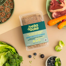 Packaged food with bella+duke label surrounded by fresh produce on a beige surface