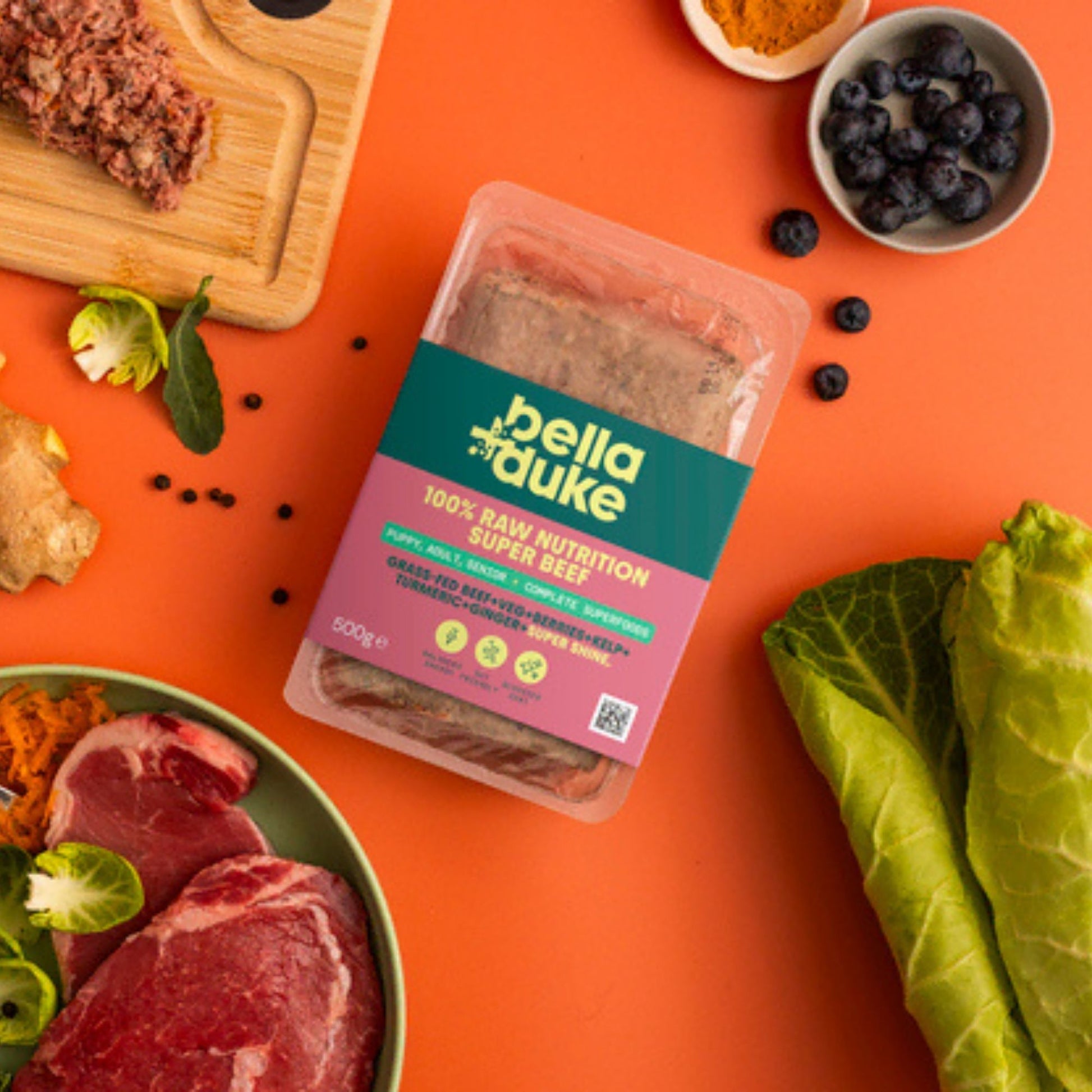 Packaged food with 'bella duke' branding on an orange background with ingredients around it.