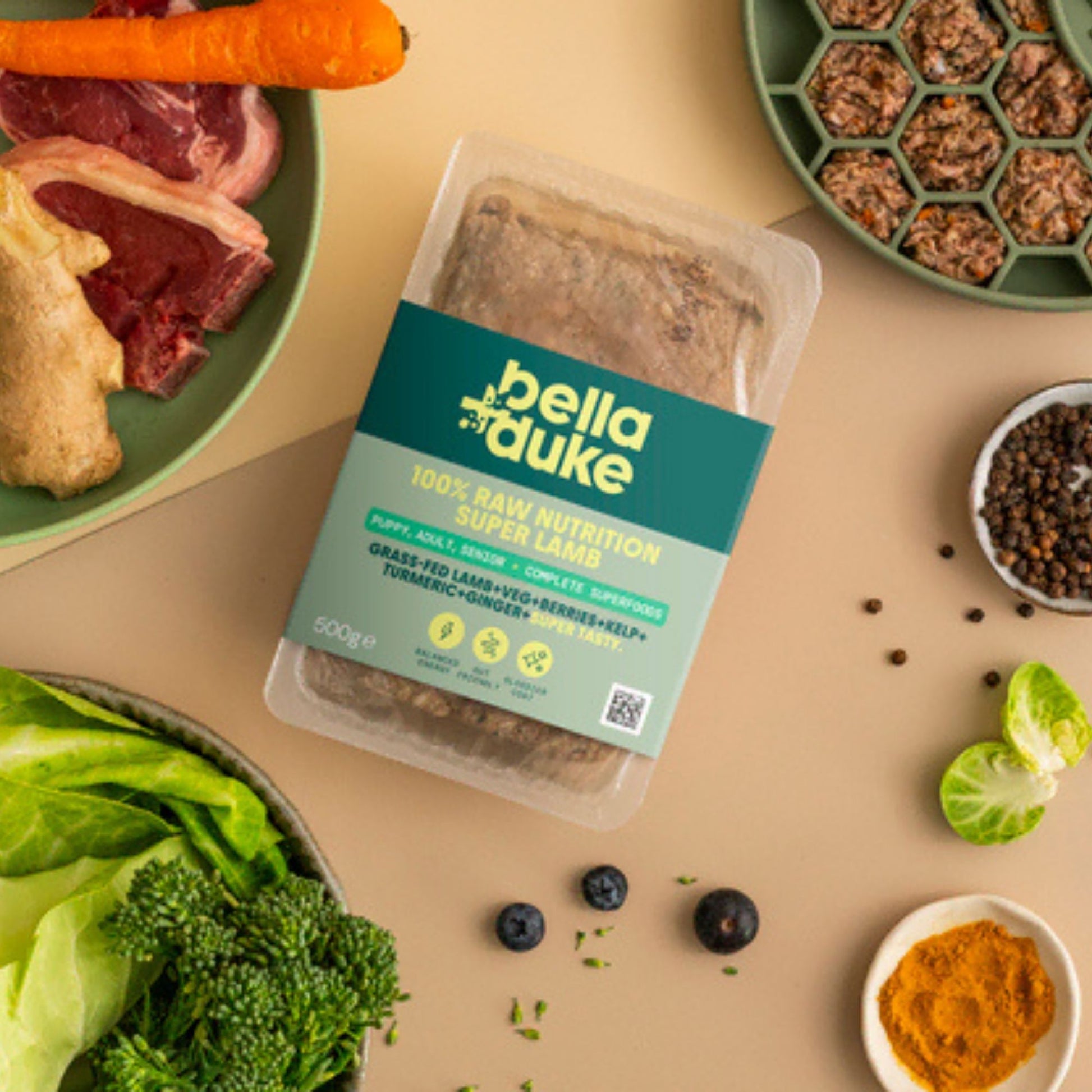Packaged food with bella+duke label surrounded by raw ingredients on a beige surface