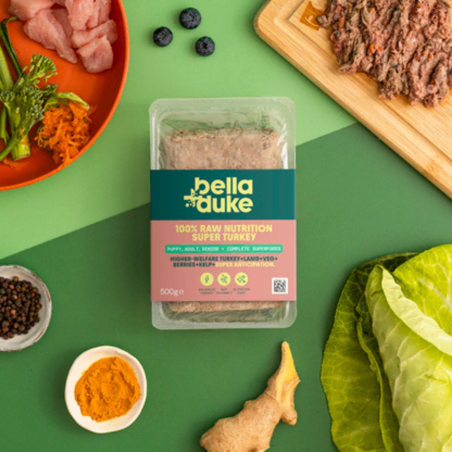 Packaged food with bella+duke branding on a green background with ingredients around it.