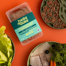 Packaged pet food with bella+duke branding on an orange background