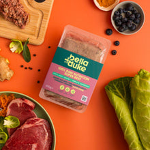Packaged food with 'bella duke' branding on an orange background with ingredients around it.