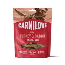 Carnilove Turkey & Rabbit dog jerky in a red stand-up pouch with a dog illustration at the top and a clear window showing the jerky pieces inside.