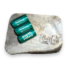 A roll of Earth Rated Poop Bags Unscented with 15 bags displayed on a wooden surface.