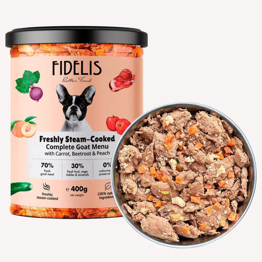 A tub of FIDELIS Better Touch Freshly Steam-Cooked Complete Goat Menu dog food next to a metal bowl filled with the cooked wet food, on a light gray background.