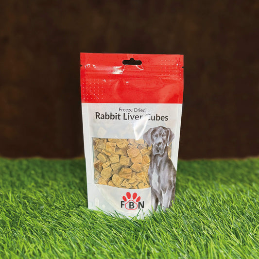 Package of FBN Rabbit Liver Cubes for dogs on grass with a brown background