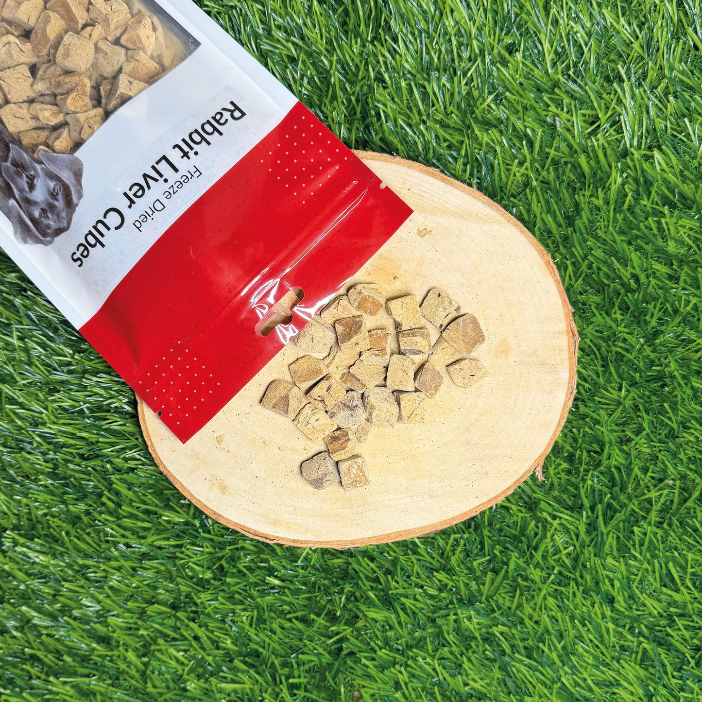 Bag of rabbit liver cubes on a wooden board with grass background