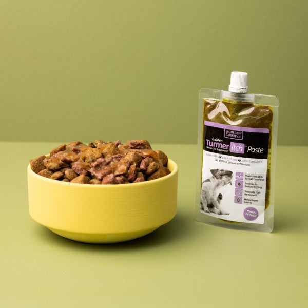 Yellow bowl with pet food and a package of Turnier Pet Care product on a green background
