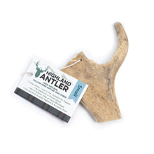 A small natural deer antler dog chew tag with a white paper label that reads 'Highland Antler' and 'Small', shown on a plain white background.