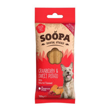 A 100g package of Soopa Dental Sticks dog treats, Cranberry & Sweet Potato flavor. The packaging features a red top and bottom border with a beige center, showing a clear window with two golden-brown dental sticks inside.