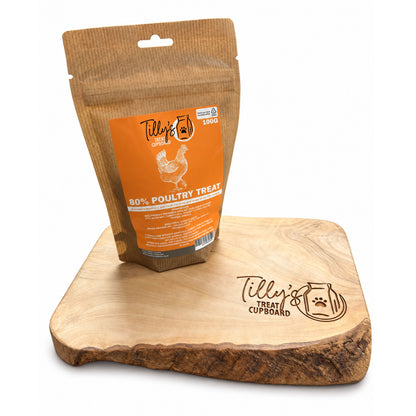 A stand-up pouch of Tilly's Pet Food 80% Poultry Treat in a brown kraft-style package with an orange label, displayed on a wooden treat cupboard against a white background.