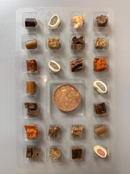 Assorted dog treats in clear plastic packaging on a gray background