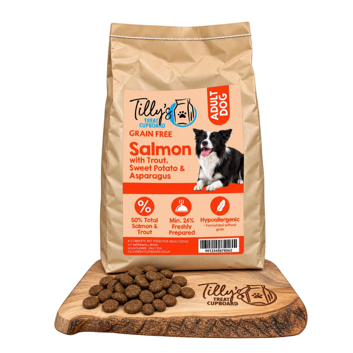 A bag of Tilly's Treat Cupboard Grain Free Salmon with Trout, Sweet Potato & Asparagus dog food stands upright on a wooden cutting board with loose kibble pieces in front. The bag is kraft paper with a large orange and white label, and the brand name Tilly's Fish is clearly visible.