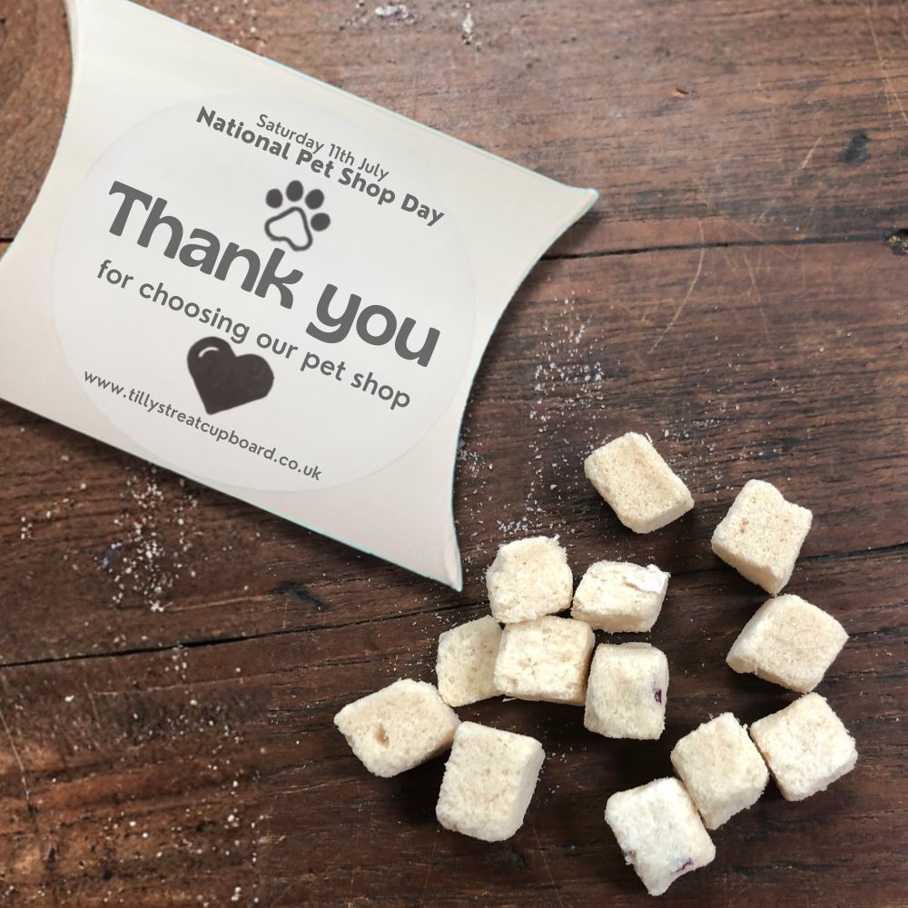 Freeze-dried Chicken & Cranberry treats spilling from a Tilly's Treat Cupboard pillow box with a "Thank you for choosing our pet shop" National Pet Shop Day sticker