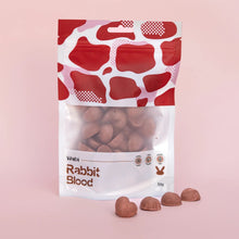 Package of rabbit blood treats with a red and white pattern on a pink background