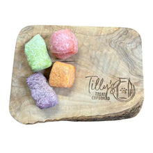 Wooden treat board with colorful dog treats and 'Tilly's Treat Cupboard' branding.